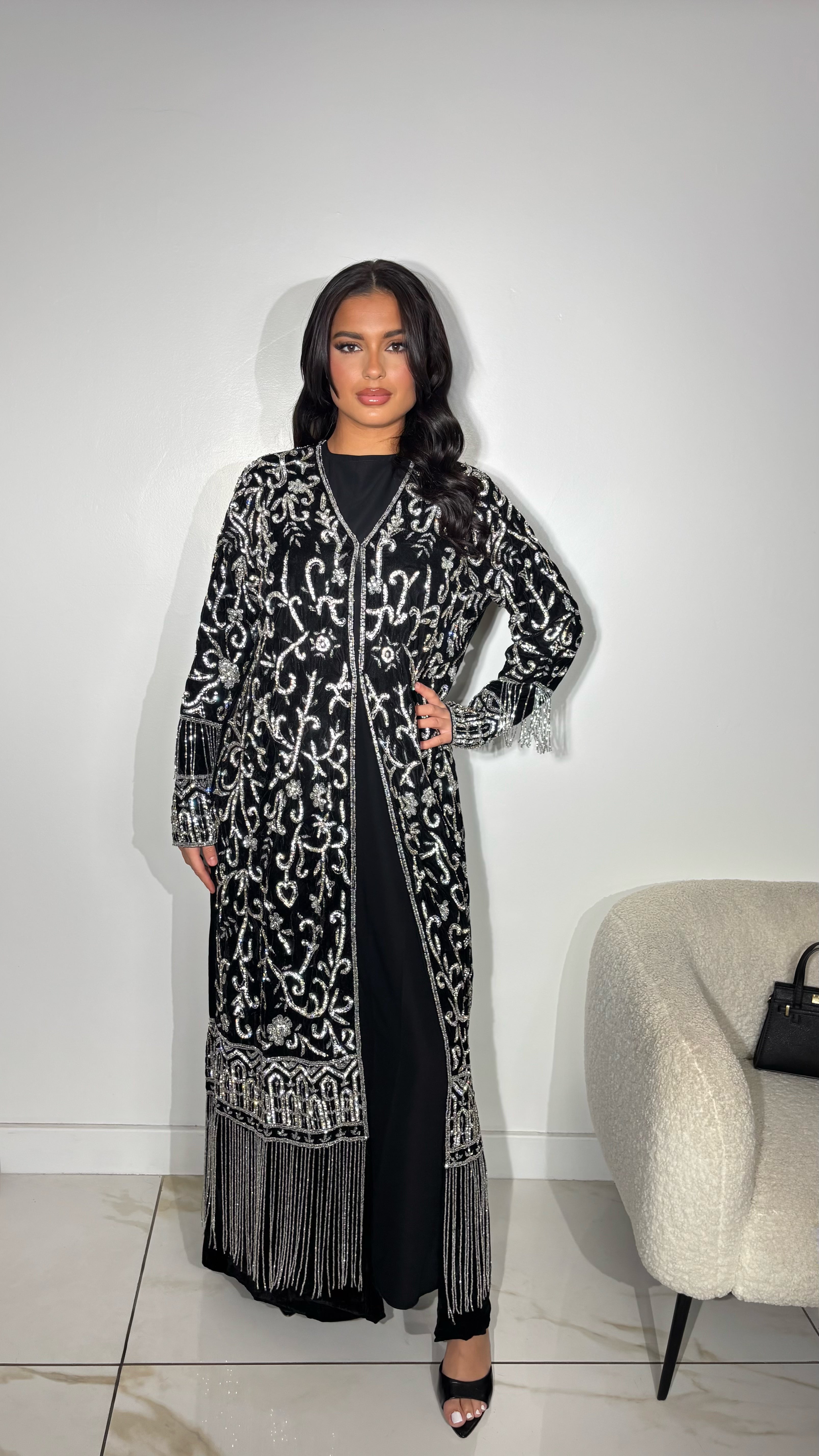 Abaya en velours noir
Perles argentés cousues à la main
Broderies raffinées aux motifs orientaux
Manches larges élégamment travaillées
Franges perlées au bras et bas de l’abaya
Idéale pour occasions spéciales et soirées
